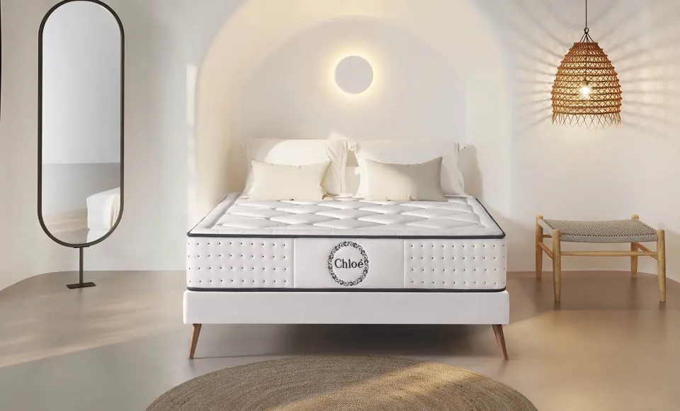 Mediterranean-style white bedroom with a Chloé mattress, a full-length mirror and a rattan lamp