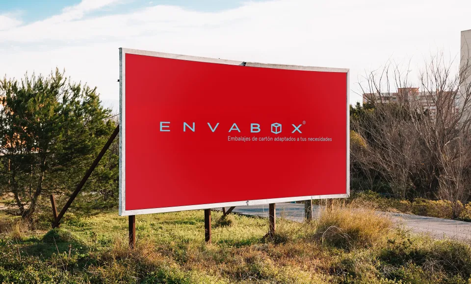 Red Envabox billboard installed in a field beside the road