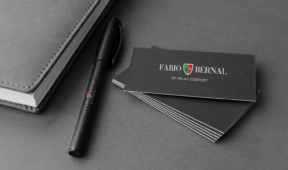 Fabio Bernal notebook, pen and business cards on a dark grey surface