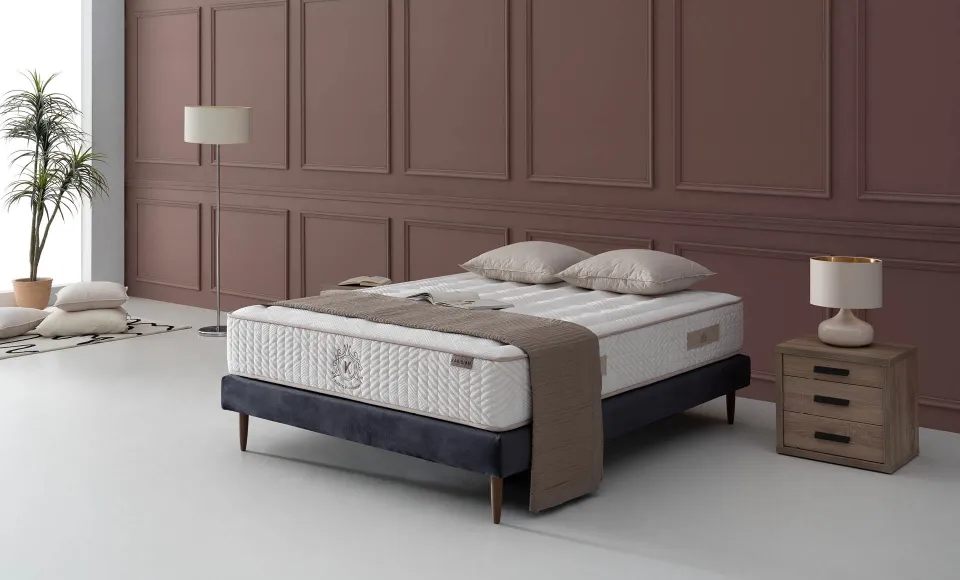 Cama con colchón acolchado de Karibian Descanso en un dormitorio con paneles marrones