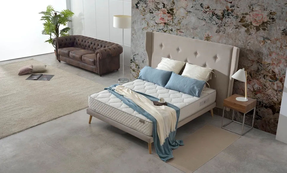 Dormitorio con cabecero tapizado beige, papel floral y colchón de Karibian Descanso