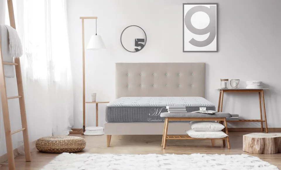 Bed with a beige headboard in a child's bedroom with a decorative ladder and round mirror