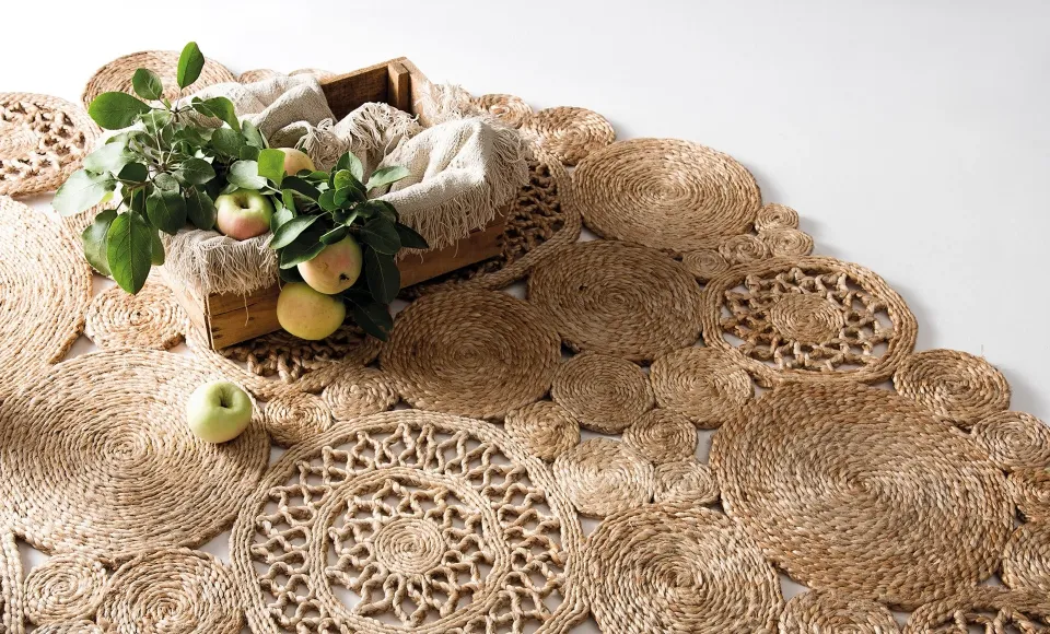Parentesi Quadra woven jute rug with a crate of apples and greenery