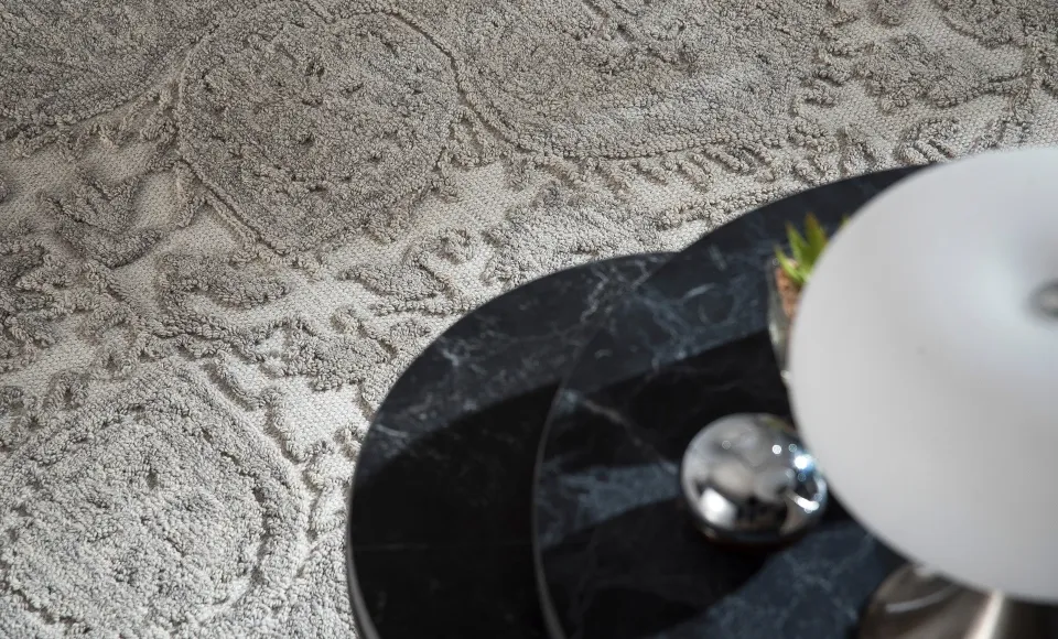 Textured cream rug with black marble trays by Parentesi Quadra
