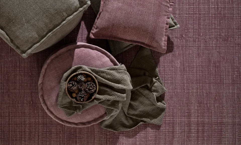 Linen cushions on a mauve woven rug by Parentesi Quadra