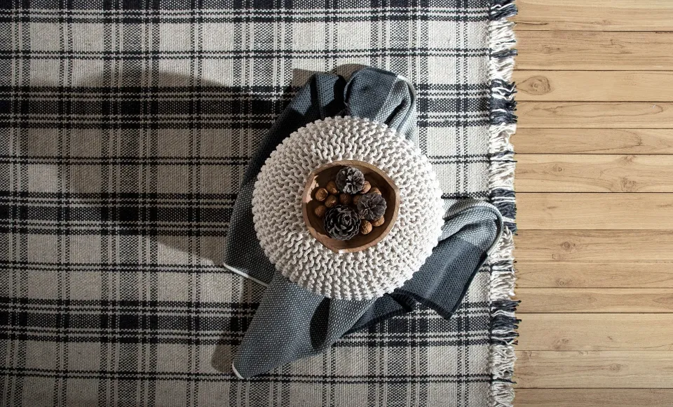 Grey check wool throw with a woven cushion and pine cones by Parentesi Quadra