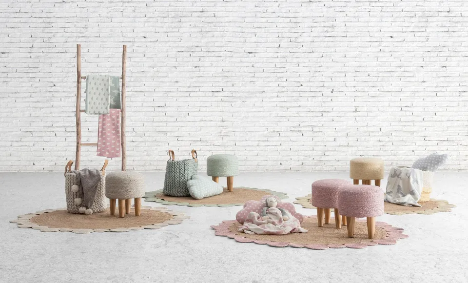 Pastel-toned pouffes and textiles by Parentesi Quadra on round jute rugs