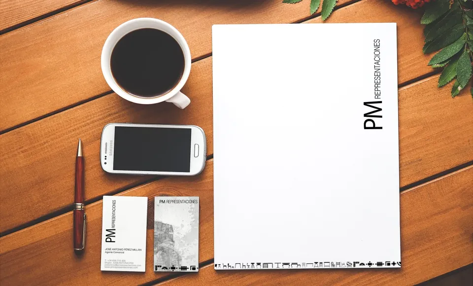 PM Representaciones stationery: letterhead, business cards and phone on a wooden table