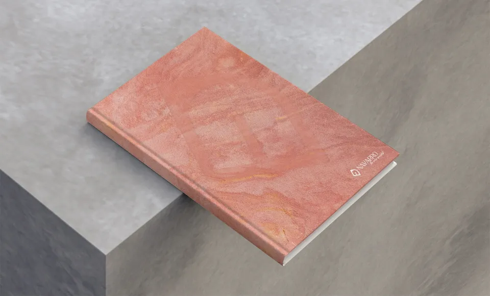 Tapicerías Navarro catalogue with a pink marble cover, shown at an angle on a block