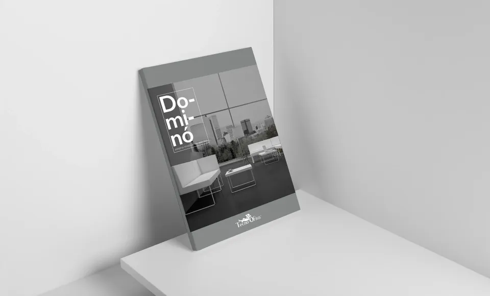 Tecno Offis Dominó catalogue shown at an angle, with office furniture photos on the cover