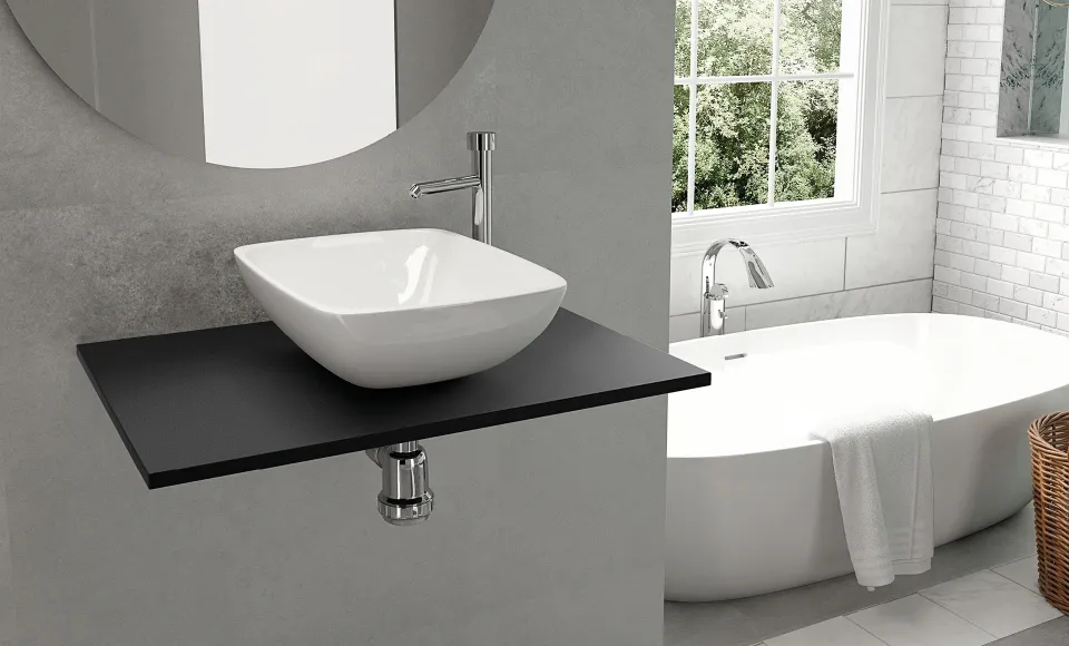 White countertop basin on a black shelf beside a freestanding bathtub, in a bathroom overlooking a garden